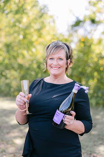 Kelli holding a bottle of champagne at  Parkside Dental