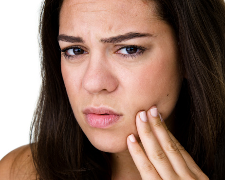A woman Suffering from a sore jaw due to TMJ