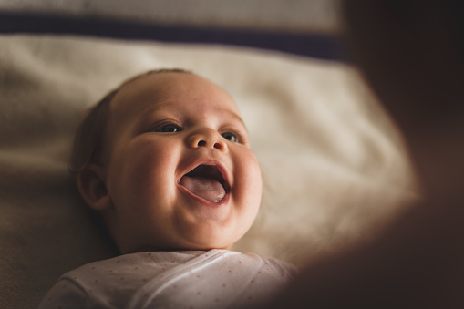 baby smiling and with mouth open showing tongue