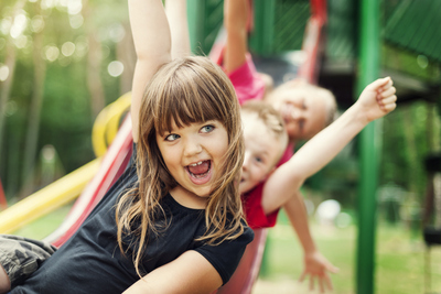 Smiling girl going down a slide